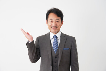 左側を手の平で指す中年のビジネスマン　白背景