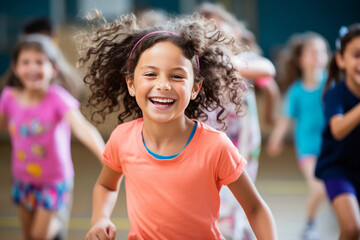 M&auml;dchen lacht und hat Spa&szlig; beim Sportunterricht f&uuml;r Kinder in der Turnhalle, Kinderturnen, Gesunde Bewegungsf&ouml;rderung