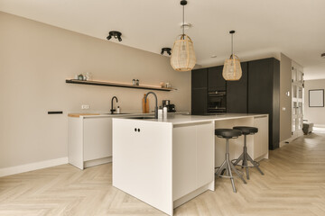 a kitchen and dining area in a modern apartment with wood flooring, white cabinets and black bar stools