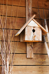 Wooden birdhouse on the wooden wall of an old house.