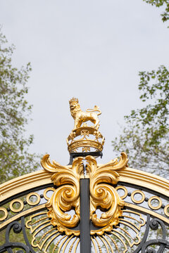 Golden lion finial atop ornate gilded wrought iron gate at Buckingham Palace, London, United Kingdom