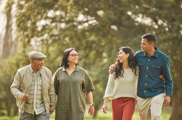 Love, walking and smile with big family in park for bonding, support and summer. Vacation, happy and holiday with people relax in grass field in nature for peace, generations or care together