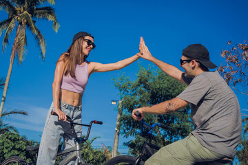 Young happy couple enjoy BMX riding at the skatepark