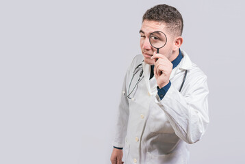 Doctor holding magnifying glass and looking at camera on isolated background. Doctor with...