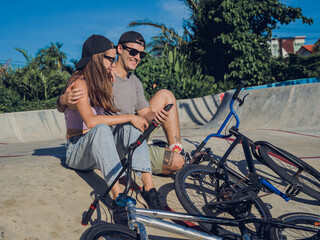 Young happy couple with BMX taking selfie at the skatepark