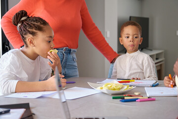 African family having a snack while painting or doing the homework. Family spending time together.