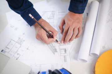 Architect engineer contractor design working drawing sketch plan blueprint. Concept architects, engineer holding pen pointing equipment architects On the desk. Selective Focus