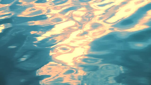 Beautiful opalescent orange sunset light shining blue water, rippled waves, calm natural crystal clean fresh water, effect, scene, wavy, wet, pool, slow motion, close up, full frame, hd. ProRes 422 HQ