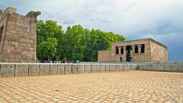 Tourists visiting the Temple of Debod Monument in Madrid Spain in Europe. People walk by the Ancient Egyptian temple and museum from Aswan located in Madrid the capital of Spain.