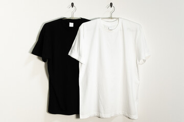 ハンガーにかけられた白と黒のTシャツ