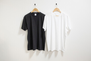 ハンガーにかけられた白と黒のTシャツ