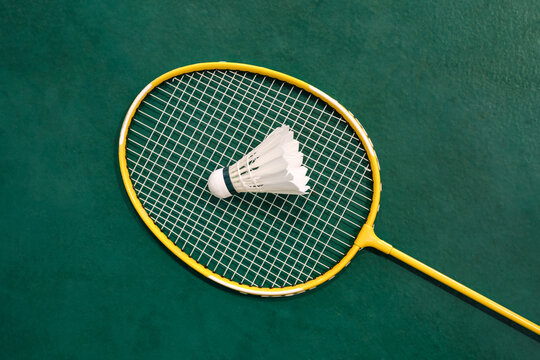 Yellow badminton racket and white badminton shuttlecock