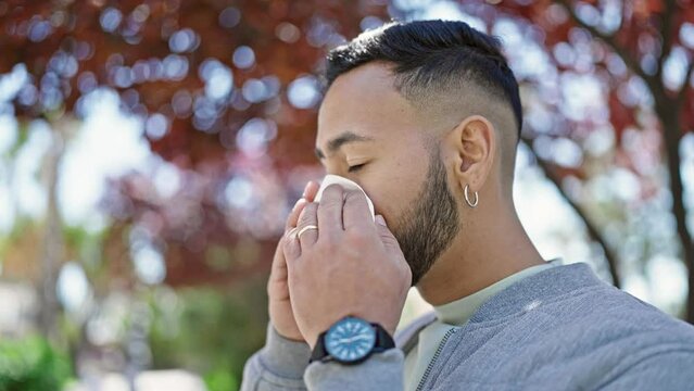 Young hispanic man with pollen allergy at park