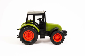 A green, orange and grey toy  farm tractor   isolated on a white background