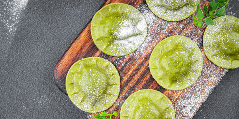 Obraz na płótnie Canvas green ravioli fresh green dough spinach, basil vegetable food meal food snack on the table copy space