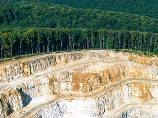 Opencast Mine Aerial View. Industrial terraces in a mining quarry. Open pit mining of dolomite. Excavation machinery of the dolomite mine. Extractive industry. Opencast mining. - obrazy, fototapety, plakaty
