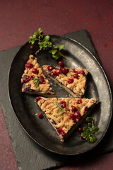 crumble with lingonberry jam on a dark vintage tray