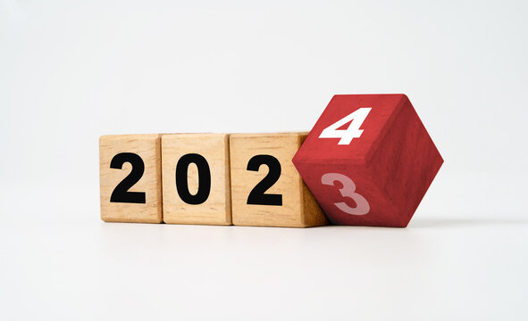 Flipping of 2023 to 2024 on wooden block cube and white background for preparation new year change and start new business target strategy concept.