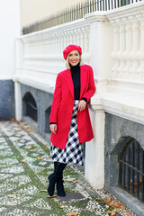 Cheerful woman in stylish outfit near fence