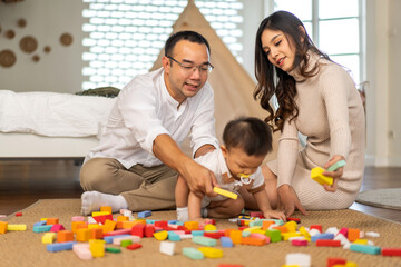 Obraz na płótnie Canvas Portrait of enjoy happy love family asian father and mother playing with adorable little asian baby.newborn, infant.dad touching with cute son moments good time play toy.Love of family