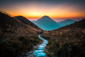 sunset in the mountains with pathway in the middle