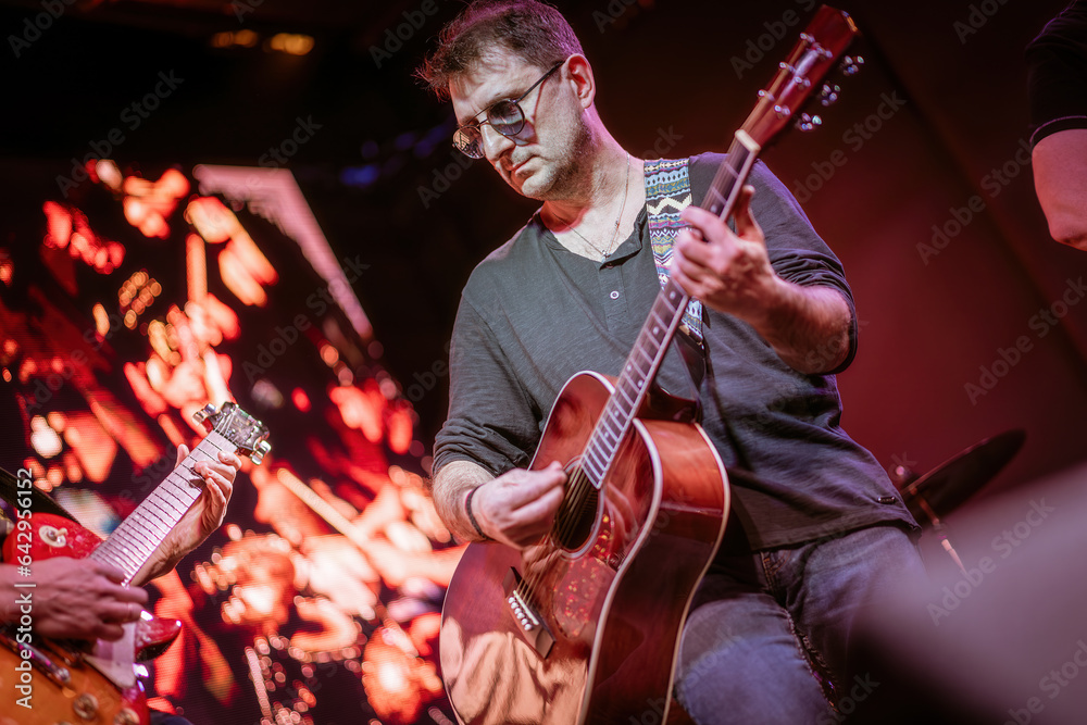 Poster band performs on stage, rock music concert.