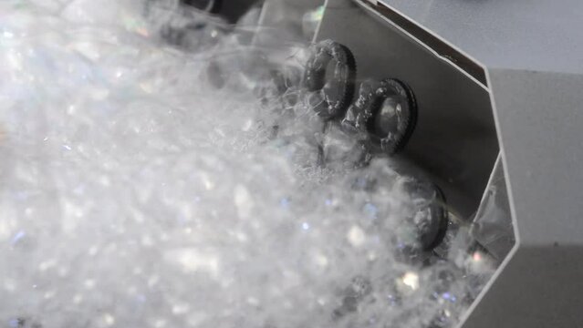 Soap bubble generator close up. Working operation Soap Bubble Generator and inflating soap bubbles. Bubble machine. Automatic blowing soap bubbles. Creating bubbles. Entertainment, celebration, party