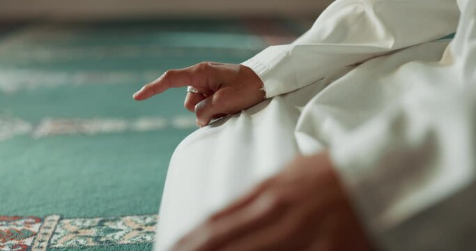 Islam, prayer and closeup of a pointing finger or person at a mosque for holy, hajj or support. Muslim, hope and hand of a man for a prayer, gesture or worship for respect, religion or trust