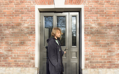 Fototapeta na wymiar young man opening the front door, warm sunny day