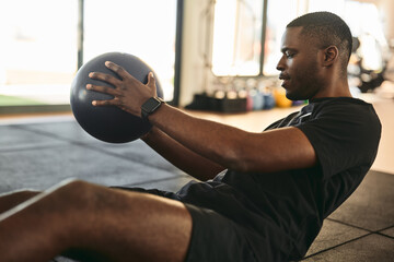 Black man doing exercises with fitness ball