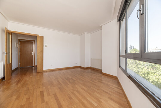 An empty room with wooden floors, white walls