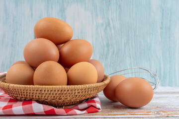 The Fresh eggs in a basket on wooden table.