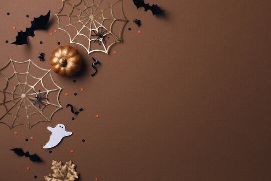 Halloween party decorations from pumpkins, bats, spider web and ghosts top view. Happy halloween holiday greeting card flat lay style..