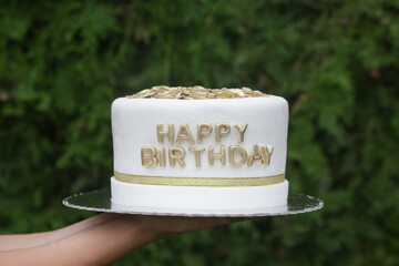 Simple and elegant white fondant birthday cake with gold flowers on top 
