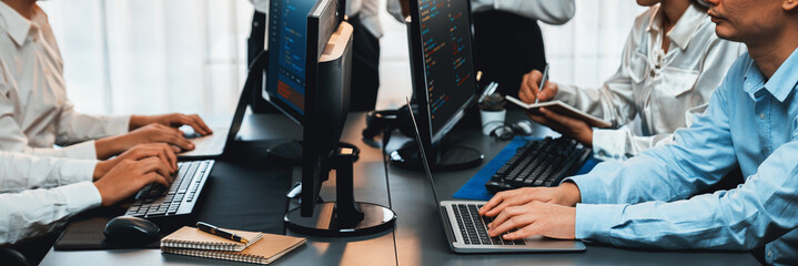 Software development team working together in office, coding script display on computer monitor....