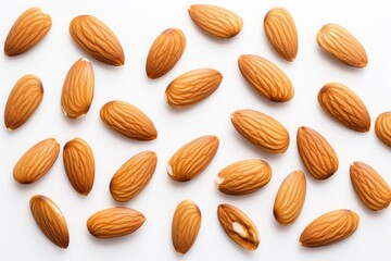 Obraz premium Almond nuts positioned on a white background, seen from above. The arrangement is flat with the nuts spread out.
