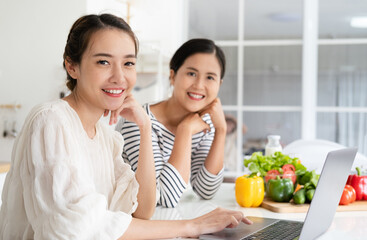 Asian women prepare ingredients for cooking follow cooking class online course on website via tablet. cooking content on internet technology for modern lifestyle concept