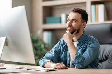 Naklejka premium Handsome Male Entrepreneur Sitting At Workplace With Thoughtful Face Expression