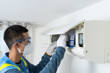 Professional male staff cleaning, air conditioning, inspection and maintenance for good hygiene and...