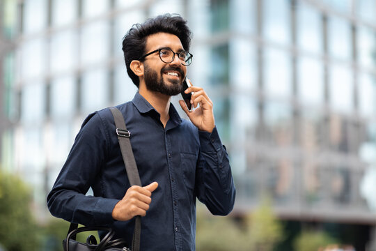 Indian entrepreneur walking by street and talking on phone