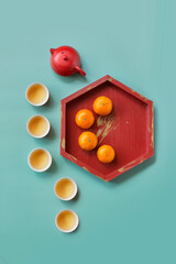 Flat lay Chinese new year decorative objects, food and tea on coloured background still life.