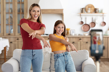 Excited mom and daughter kid dancing recording video on phone