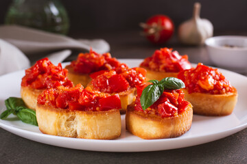 Appetizing crostini on bread with fried tomatoes and garlic on a plate