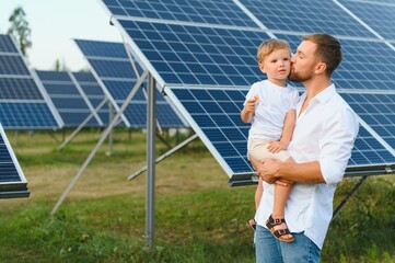 Father and his little son near solar panels.