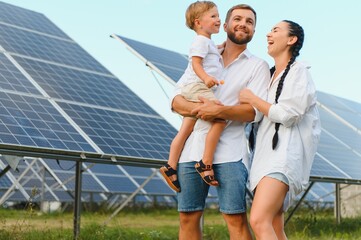The concept of green energy. Happy family walking and having fun in solar panel field. Green energy.