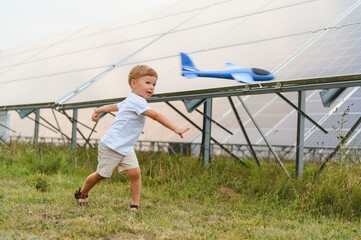 A little boy is having fun near the solar panels. The concept of solar energy.