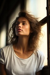 Fototapeta na wymiar Train of Contemplation: Female Model in White T Shirt by Classic Window
