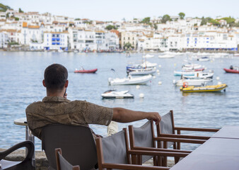 Back view of tourist looking at a village on holidays, lifestyle.