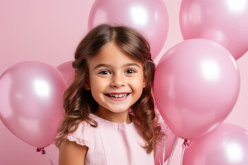 Little happy girl in pink balloons for her birthday