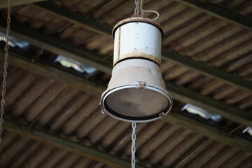 Nahaufnahme alte antike metallene Deckenlampe Industrielampe in einem verlassenen Gebäude
